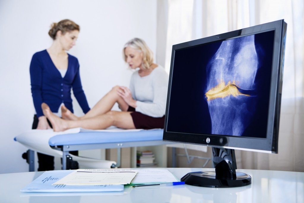 woman experiencing knee pain and getting treatment