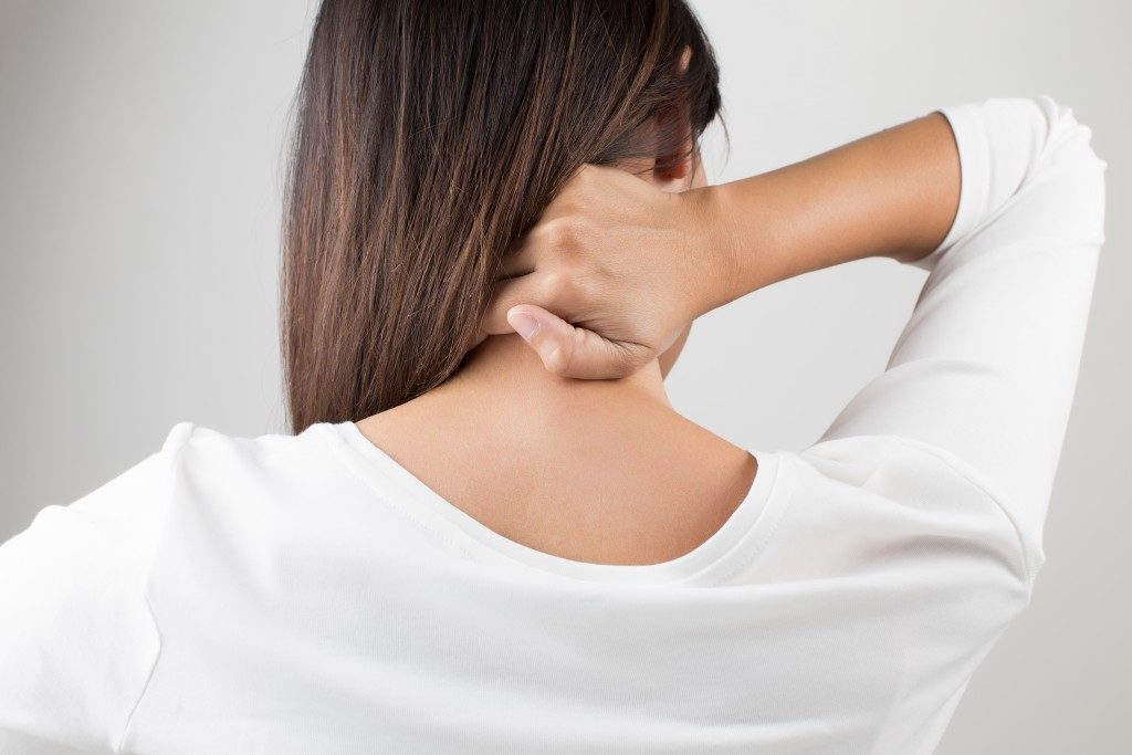 woman having pain in the back and neck