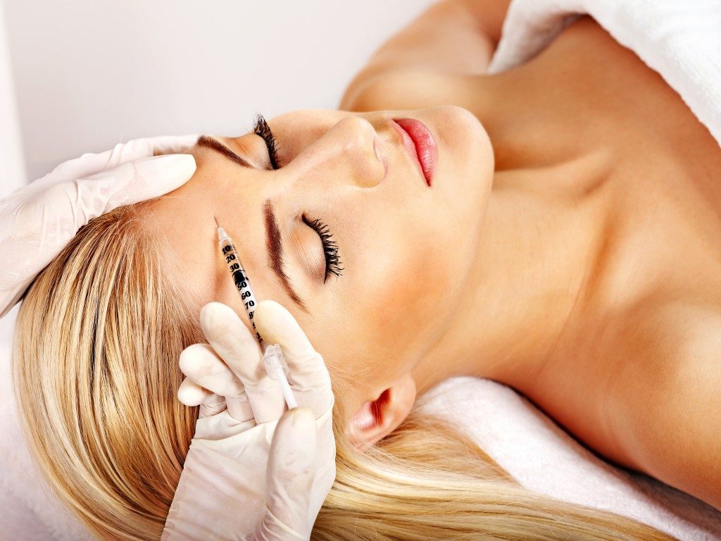 woman giving botox injections