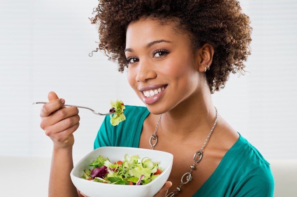 woman smiling with a salad