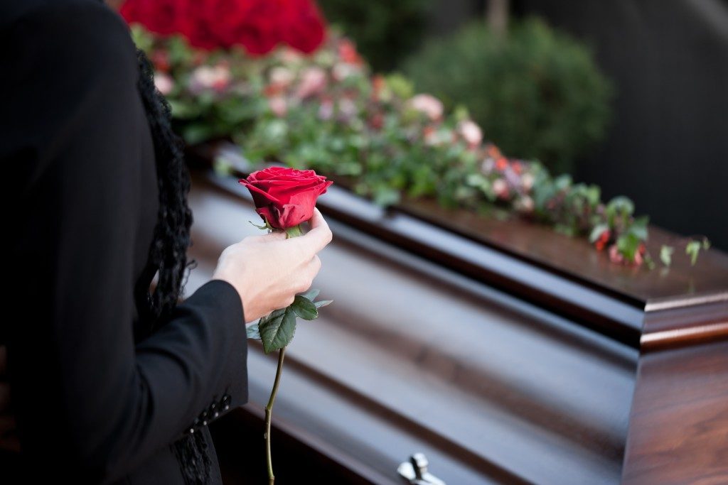 Woman carrying a rose to place above the coffin