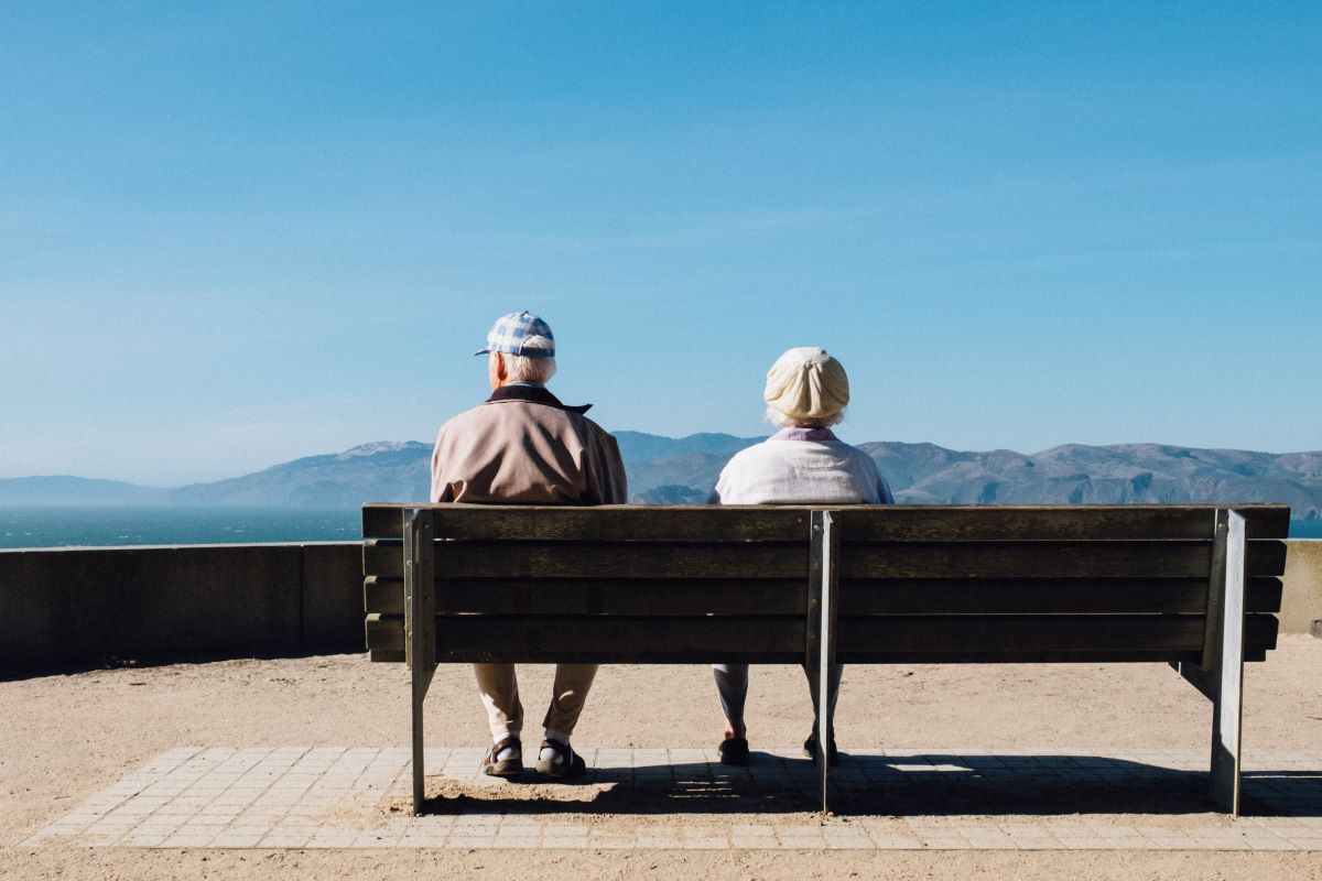 elder couple sitting at park bench