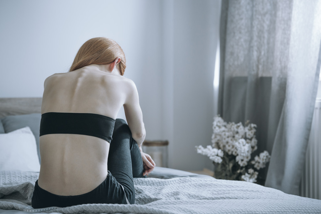 depressed woman sitting on her bed