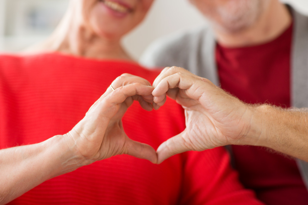 senior couple making a hand heart symbol