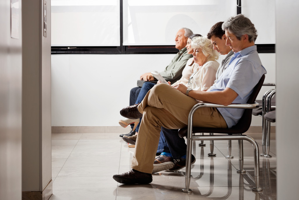 People in a hospital lobby waiting for their turn to be checked by a doctor