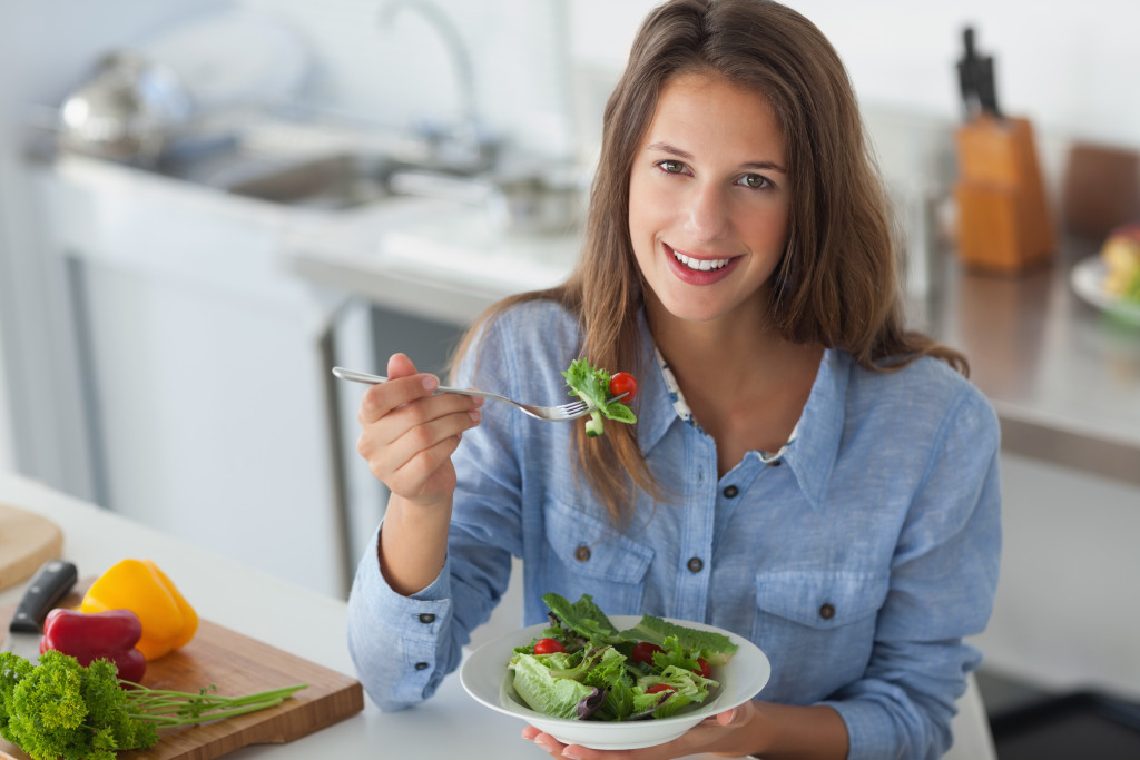 a female young adult eating a salad bowl
