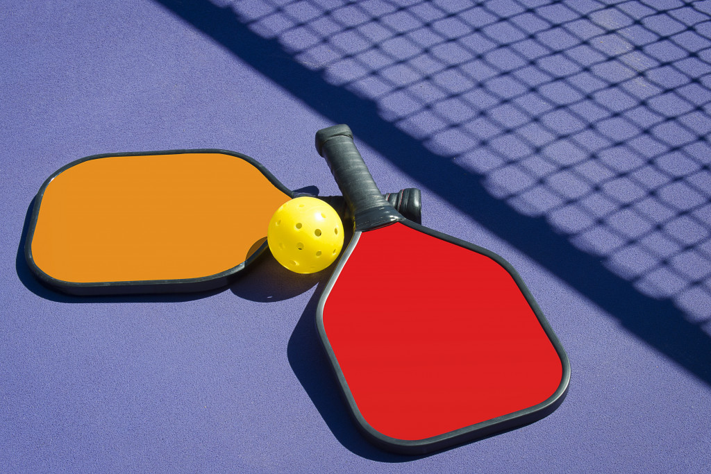 two racquet and a ball with a shadow of a net
